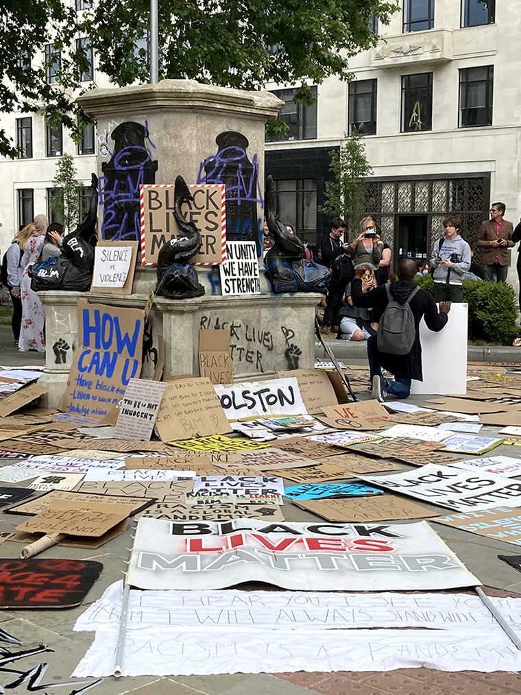 Empty pedestal of Edward Colston statue in Bristol, covered with anti-racism placards